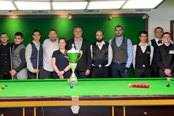 Players in the 2023 Bulgarian Snooker Championship pose for a photo by the table with the trophy on it.