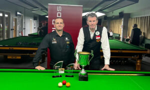 David Causier and Peter Gilchrist pose by the table and either side of the Irish Open trophies.