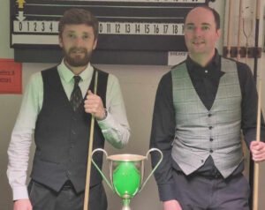 Adam Shaw and Rob Redgrove stand by the snooker table behind the trophy.