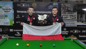 Antoni Kowalski and Mateusz Baranowski lift the trophy and hold the Polish flag.