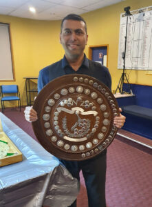 Deepak Bala holds the New Zealand National Snooker Championship shield/trophy.