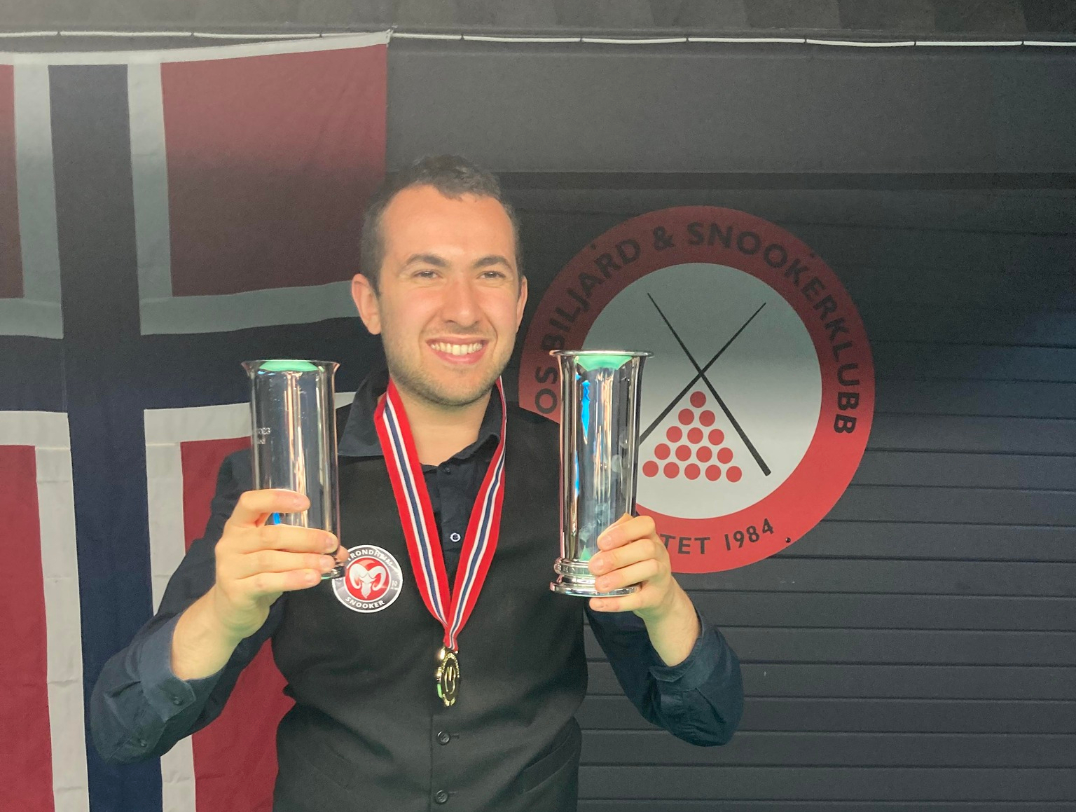 Nassim Sekat poses with his trophies and medal around his neck.