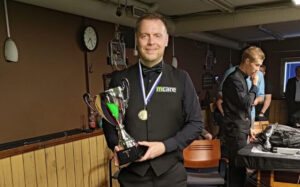 Robin Hull holds the Finnish Championship trophy and has a medal around his neck.