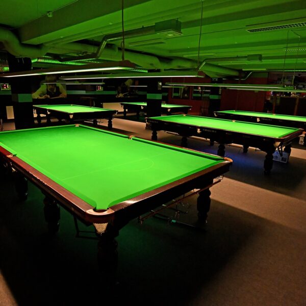 Inside the Snookerhallen venue with an image of several tables without the balls set up.